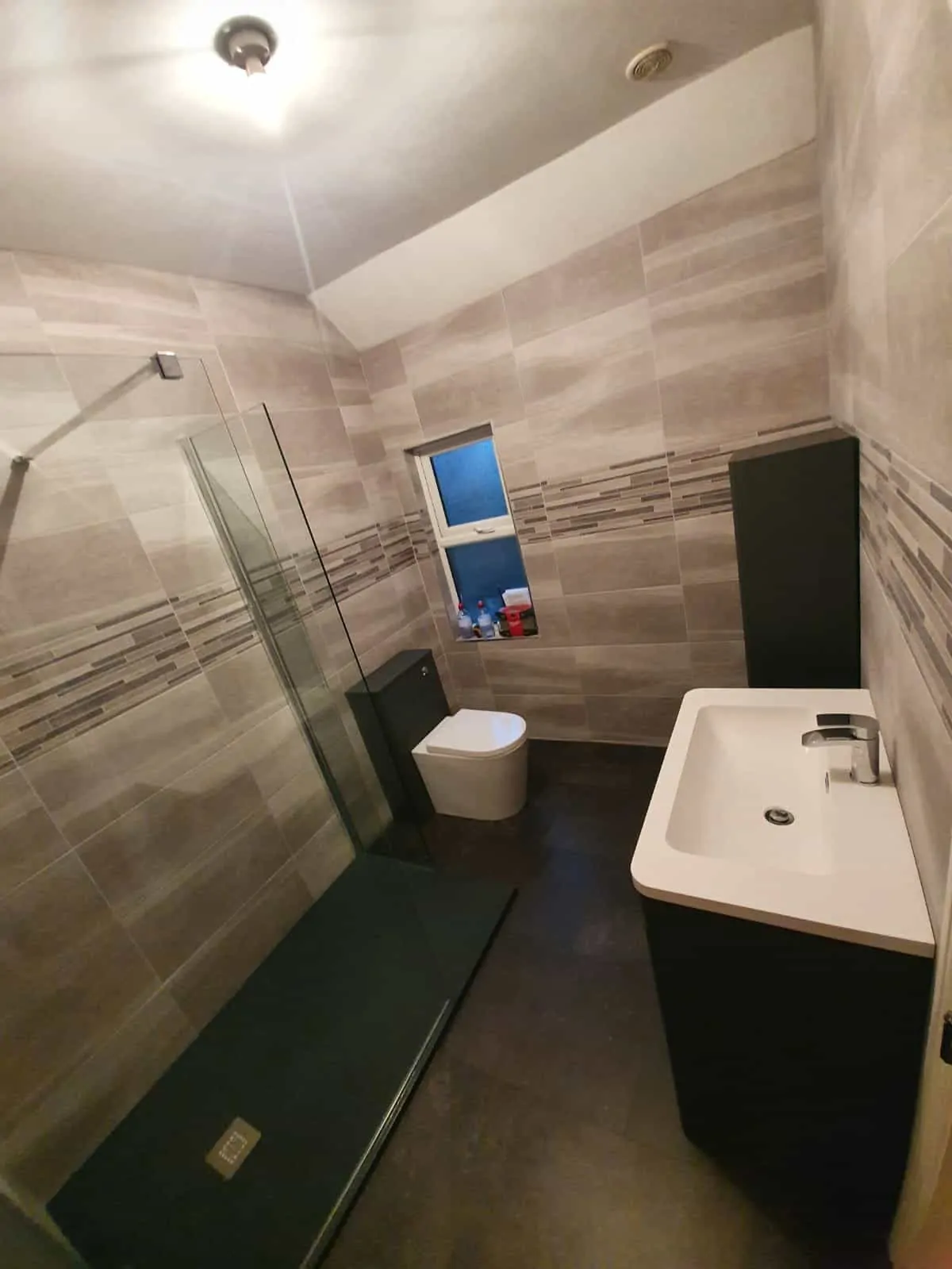 Renovated bathroom with a walk-in shower, wall-hung toilet and vanity basin