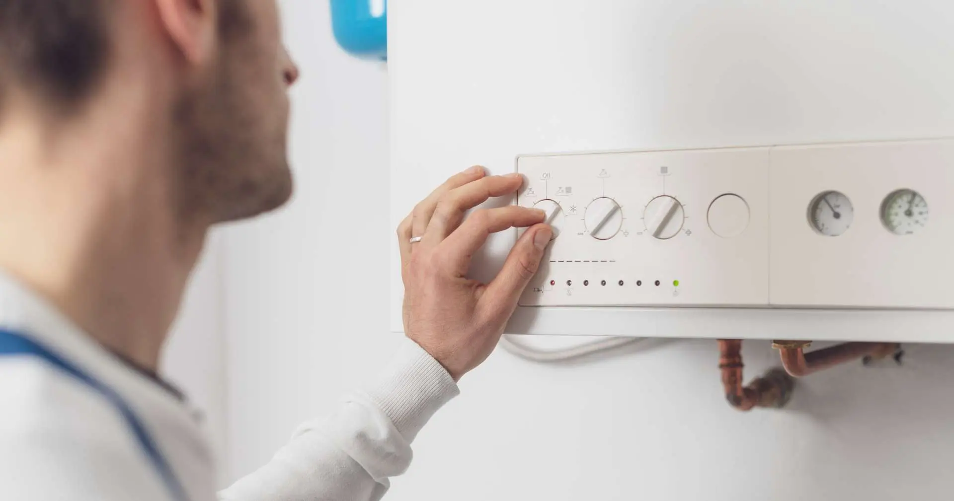 Engineer adjusting the controls on a central heating boiler