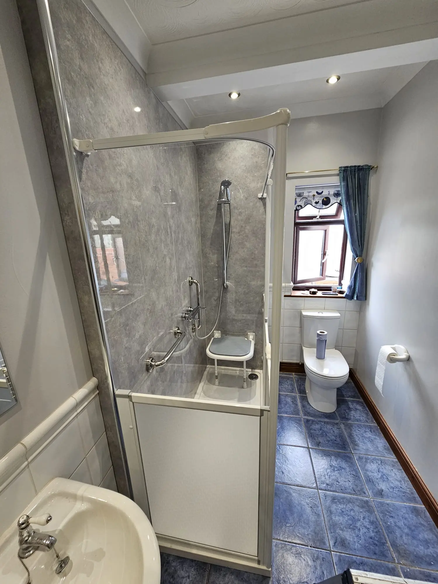 Accessible shower room with a shower seat, support rails and toilet